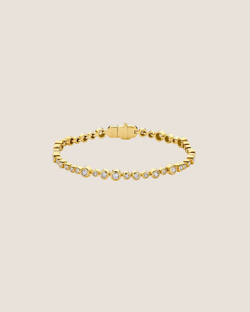 A gold tennis bracelet featuring small round-cut clear gemstones set along the front, displayed on a clean white background.