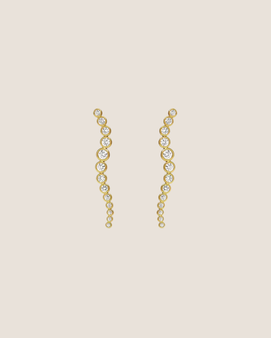 A pair of gold drop earrings with a wavy, cascading design set with clear round gemstones, displayed on a solid white background.