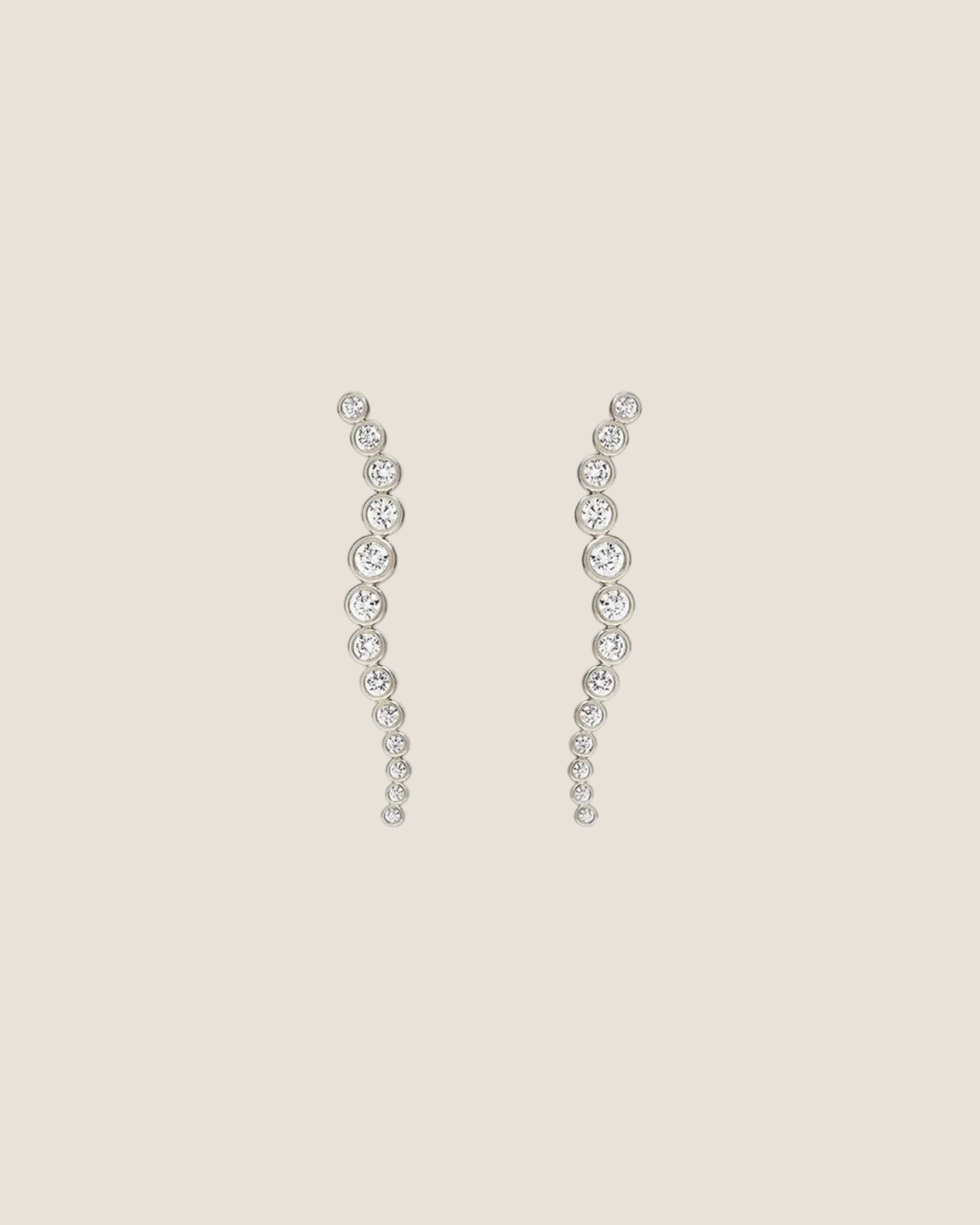 A pair of silver-toned dangle earrings with a wavy, cascading design set with clear round gemstones, shown against a plain white background.