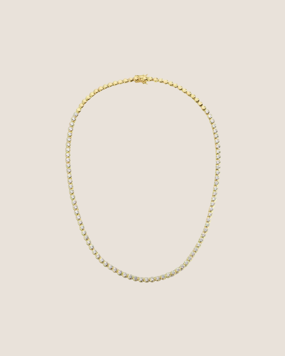 A gold tennis necklace with a small-scale beaded link design, displayed in an oval shape against a solid white background.