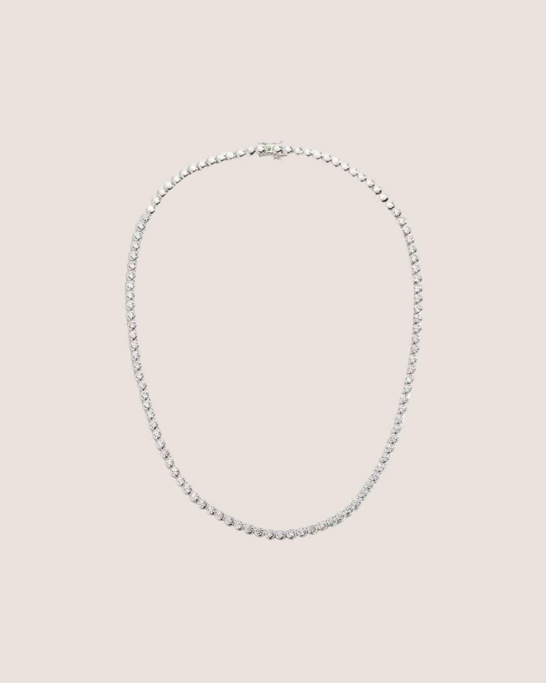 A silver tennis necklace with a continuous row of small clear stones, displayed against a solid white background.