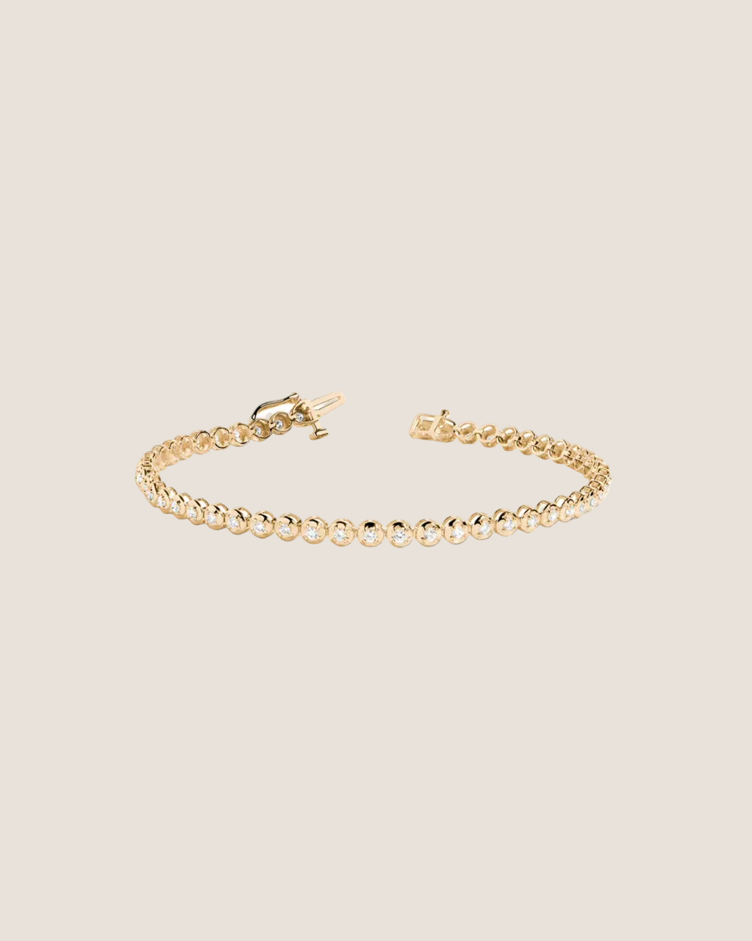 A delicate gold tennis bracelet with a beaded link design and a lobster clasp, displayed on a clean white background.